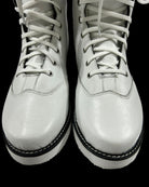 Pair of white leather boots with black soles on a transparent background