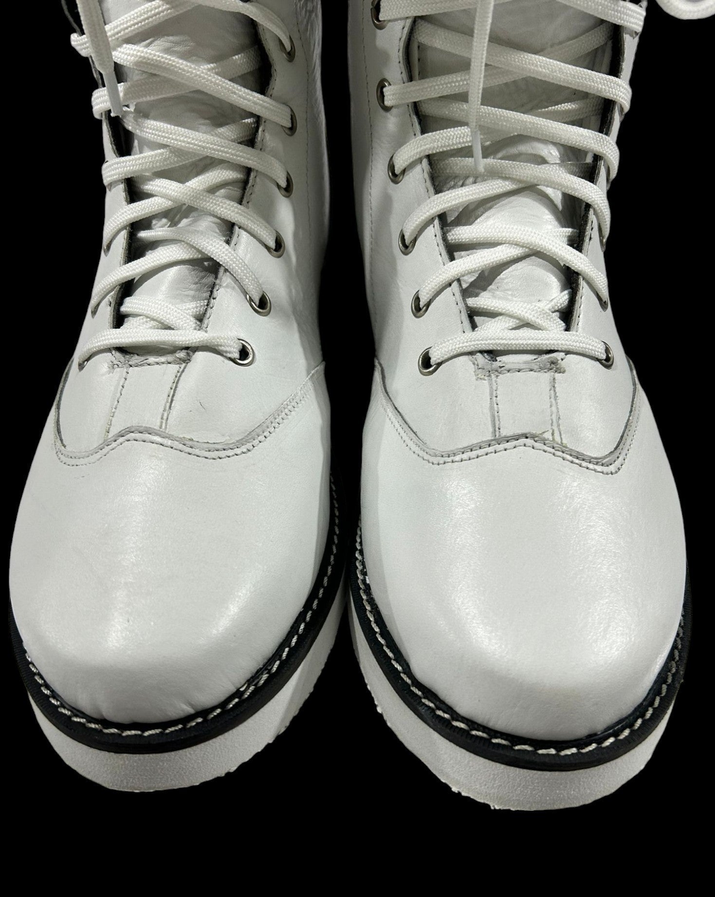 Pair of white leather boots with black soles on a transparent background