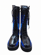 Front-facing pair of black inferno wrestling boots displaying vivid blue flame artwork covering both shaft panels 