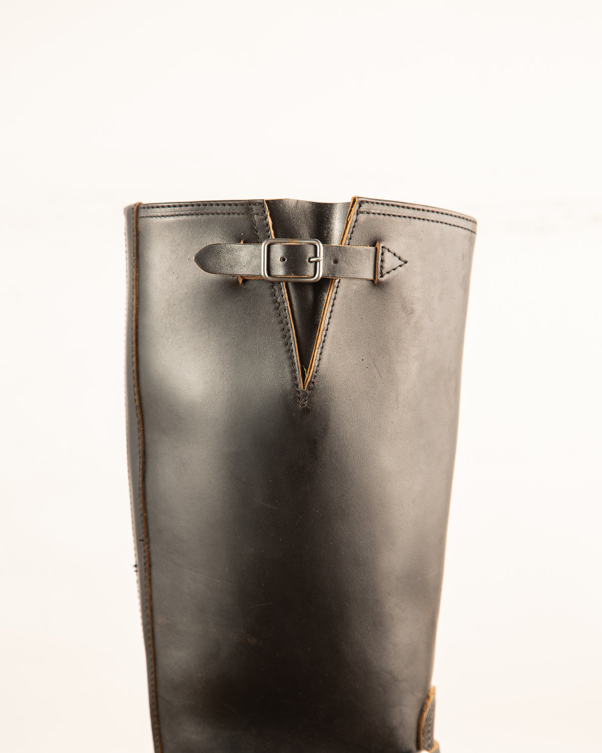 Brown leather boot with a buckle on a white background