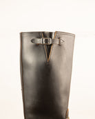 Brown leather boot with a buckle on a white background