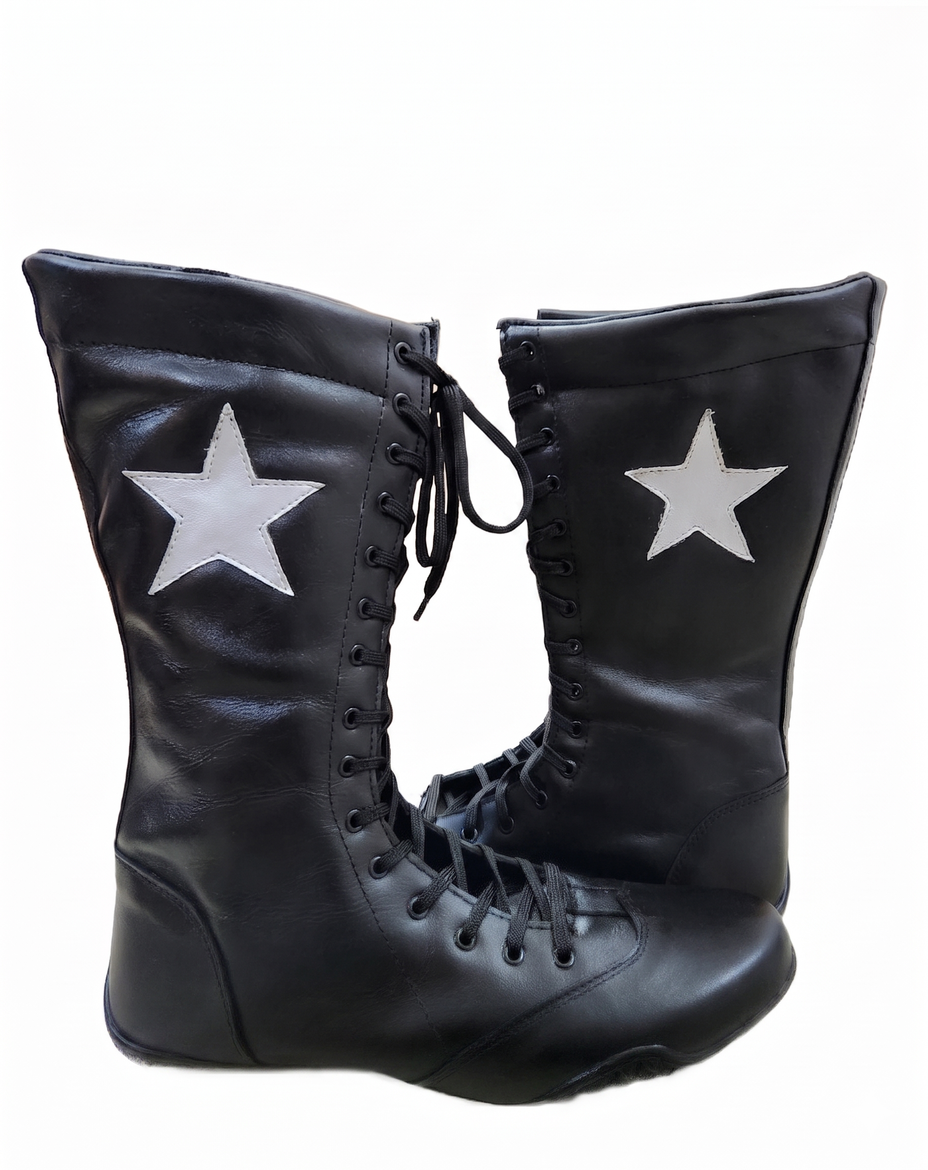 Black leather knee-high wrestling boots with white star appliqué patch on outer shaft and full black lace-up closure on white background