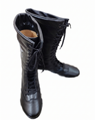 Top-down angle of black knee-high wrestling boots displaying padded collar construction and seamless all-black leather finish