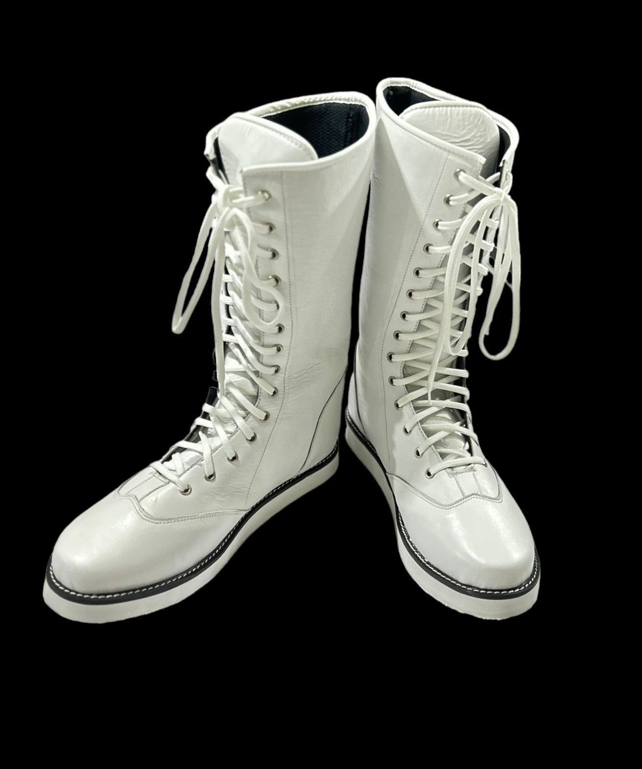 Close-up of white leather boot shaft showing silver metal eyelets and lace-up closure
