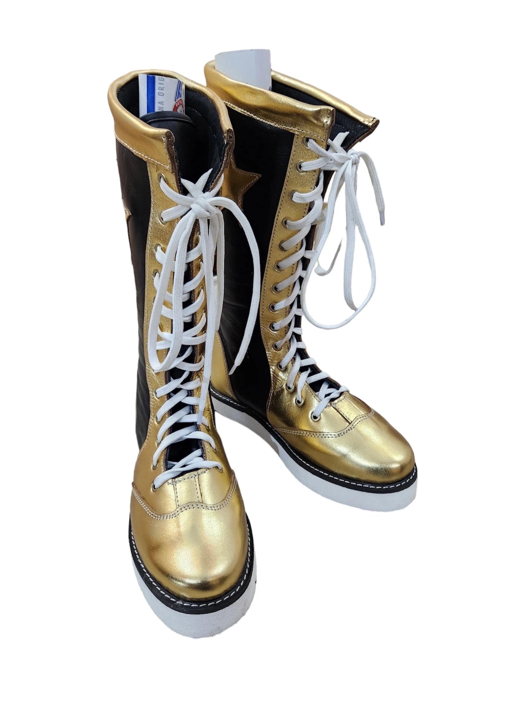 Gold and black boots with white laces on a white background