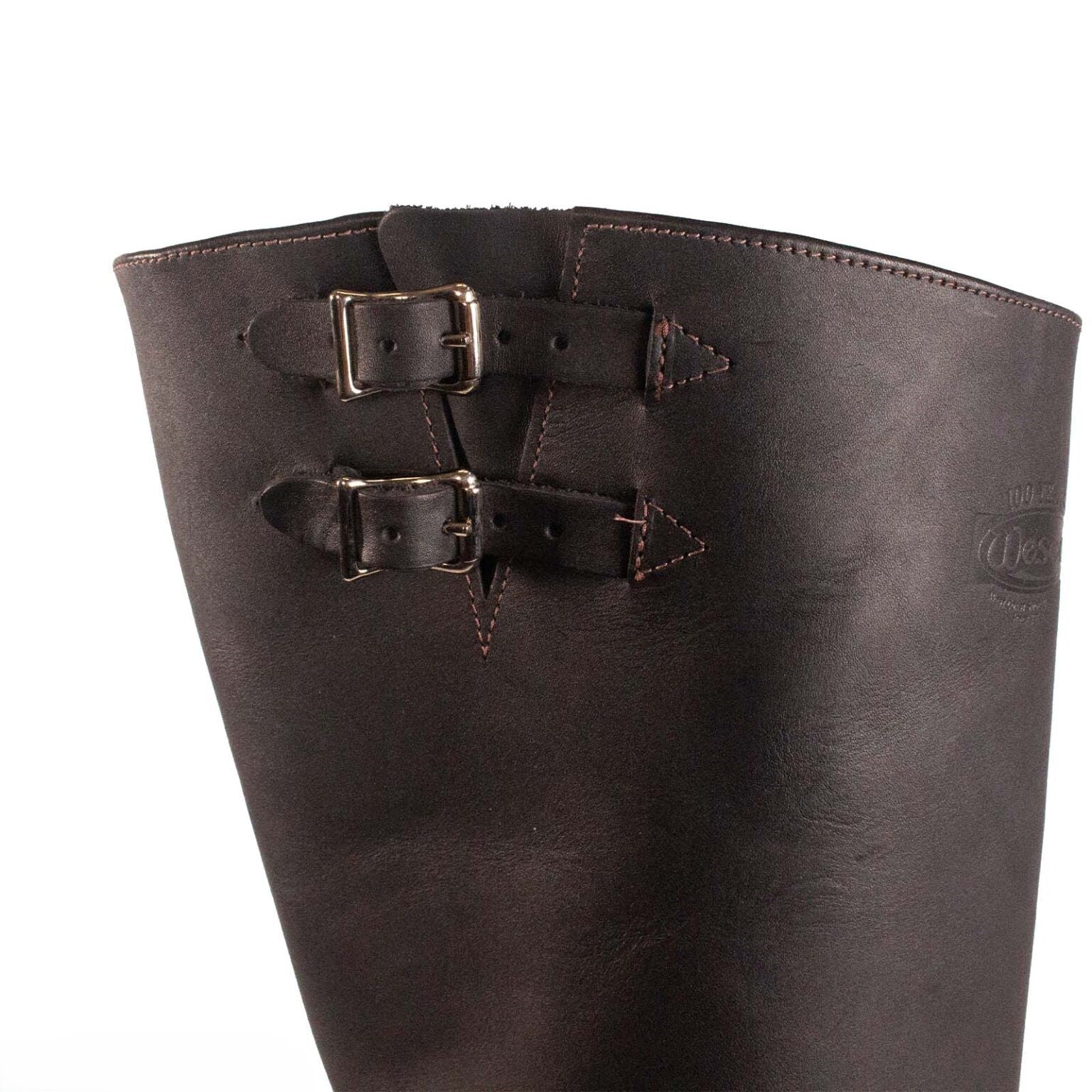 Close-up of a brown leather boot with buckles on a white background