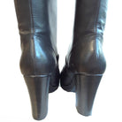 Pair of black leather knee-high boots on a white background