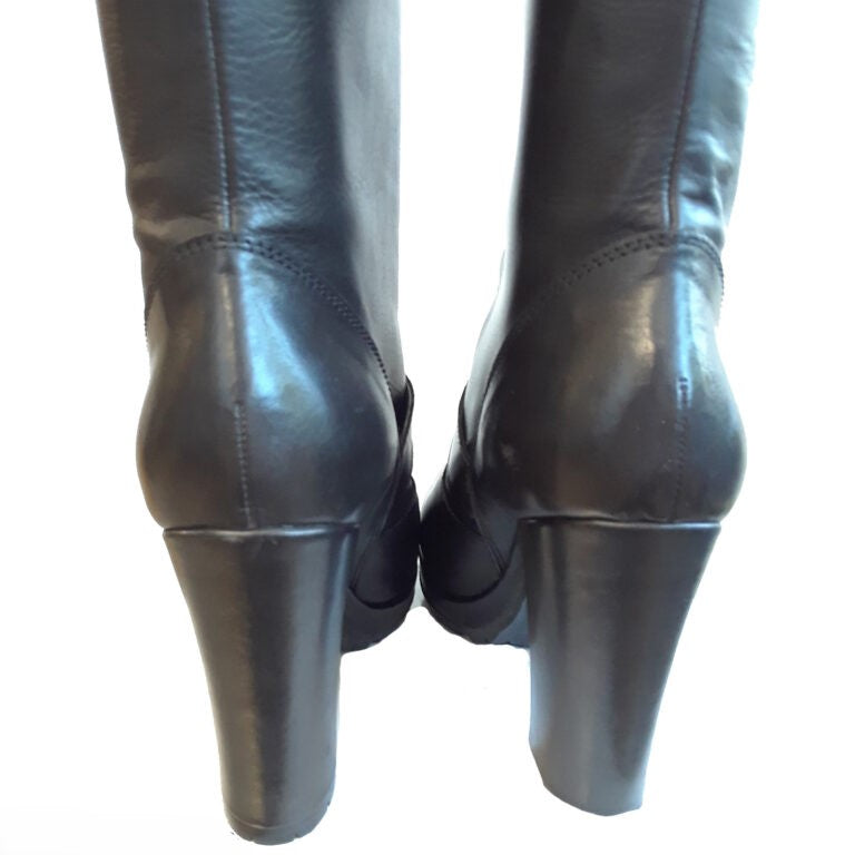 Pair of black leather knee-high boots on a white background