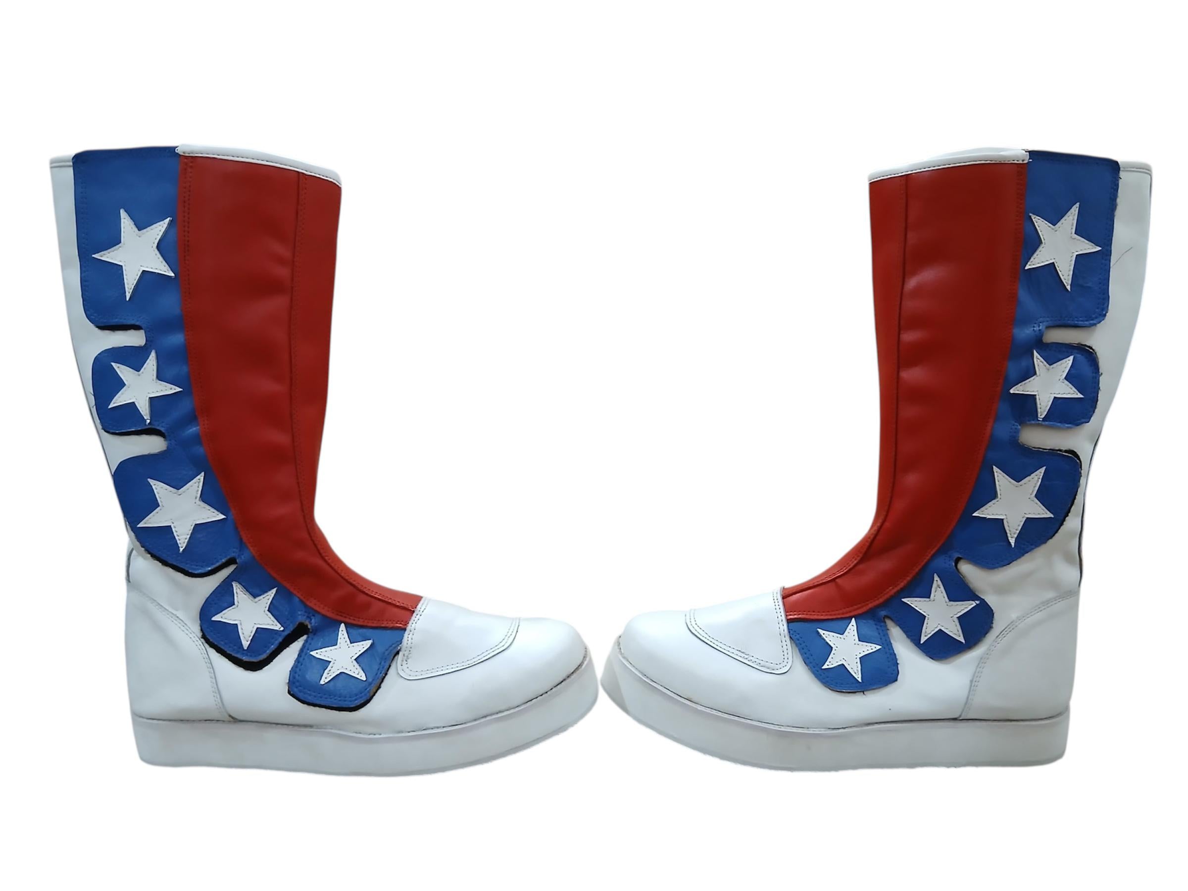 Pair of slip-on patriotic wrestling boots with white leather base, bold red diagonal stripe panel, and blue star overlay design