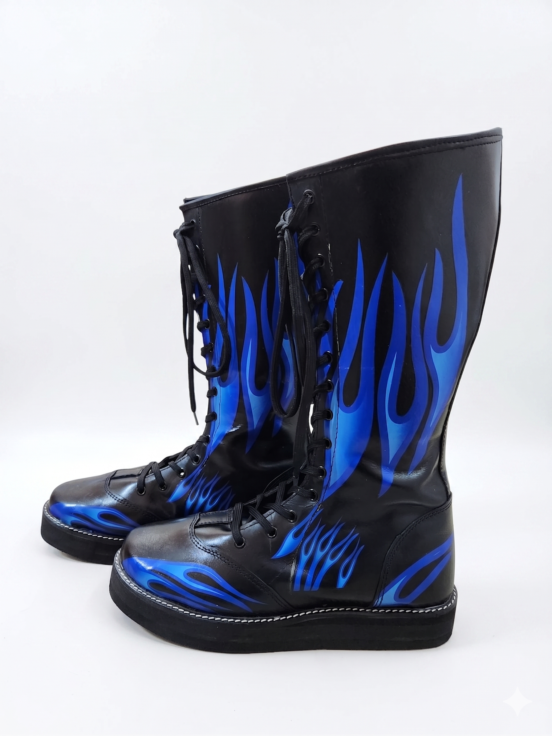 Side profile of black and blue flame professional ring boots showing full-length lace-up closure with black round laces and black metal eyelets