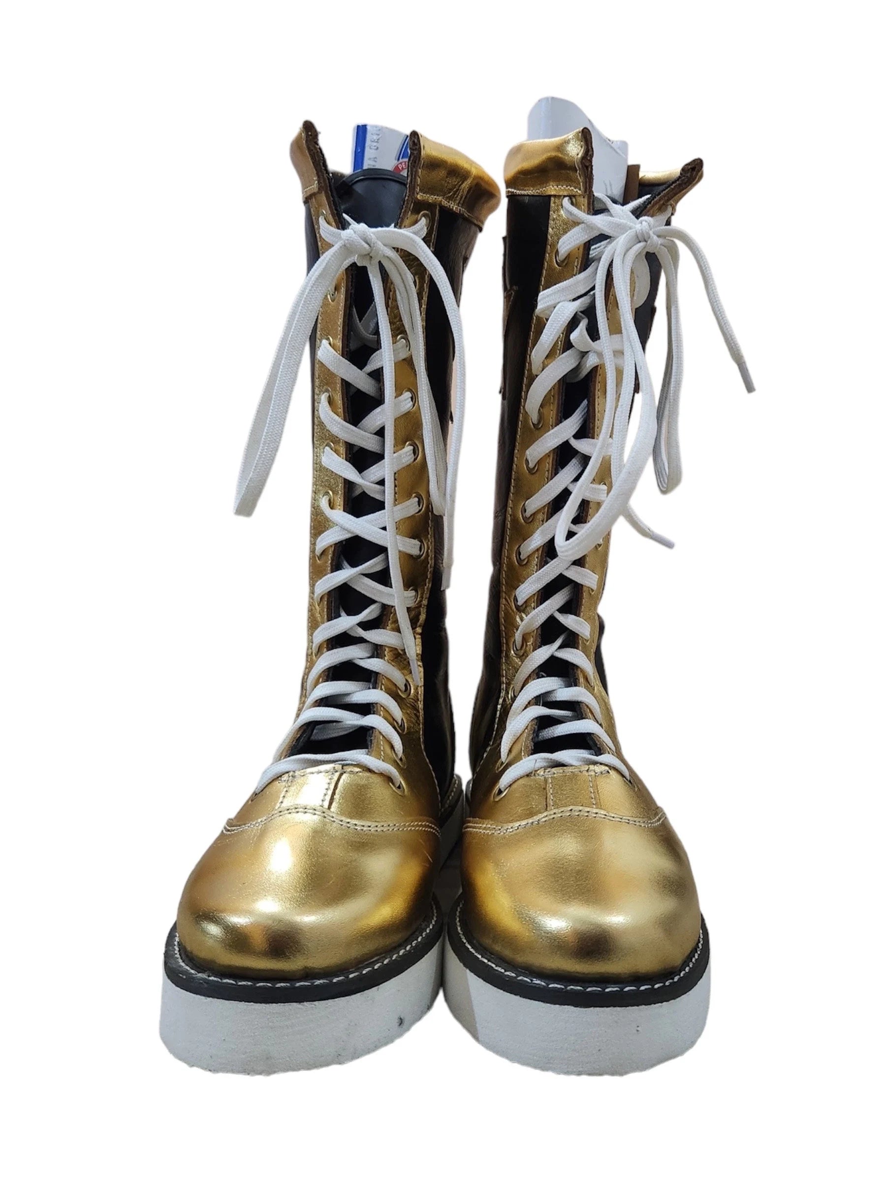 Pair of gold and black boots with white laces on a white background