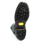 Close-up of a black boot sole with a yellow label on a white background